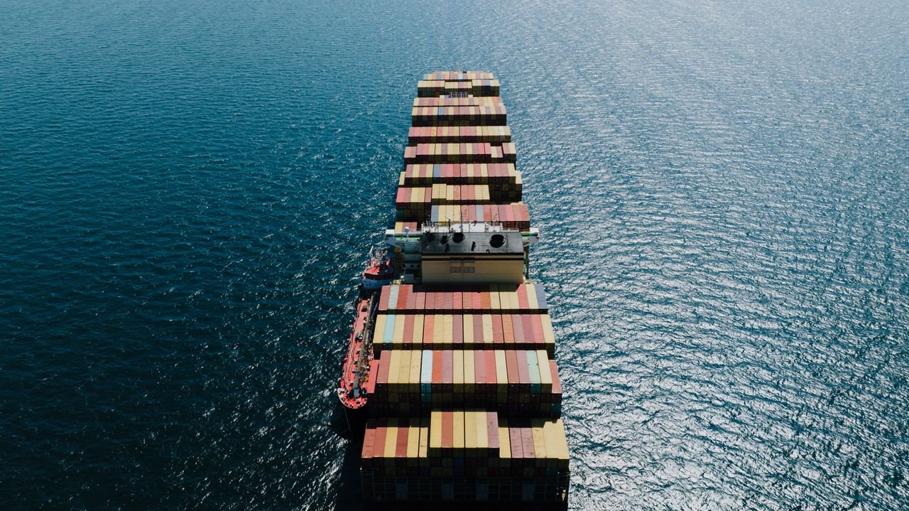 Mastering the First Impression: Your intriguing post title goes here Drone shot of a loaded container ship sailing through the sea near Naples, Italy.