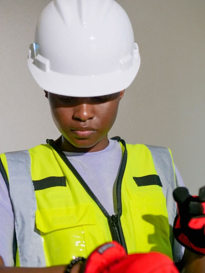 Portrait of a black woman engineer wearing PPE including hardhat and safety vest.