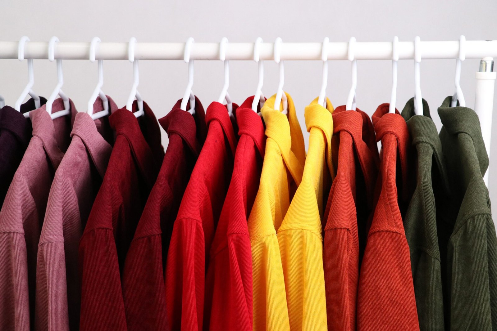Home Colorful shirts arranged neatly on a clothing rack indoors.