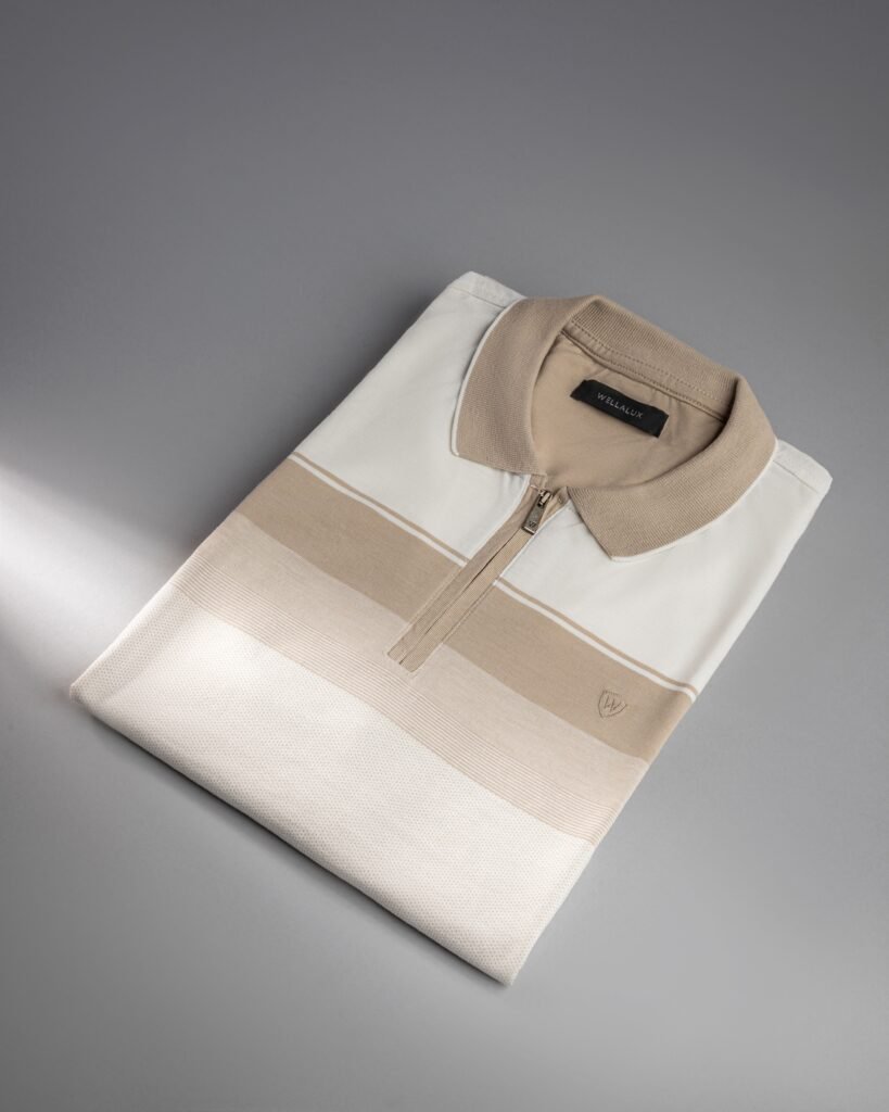 Home Stylish folded polo shirt in neutral tones on a gray studio background.