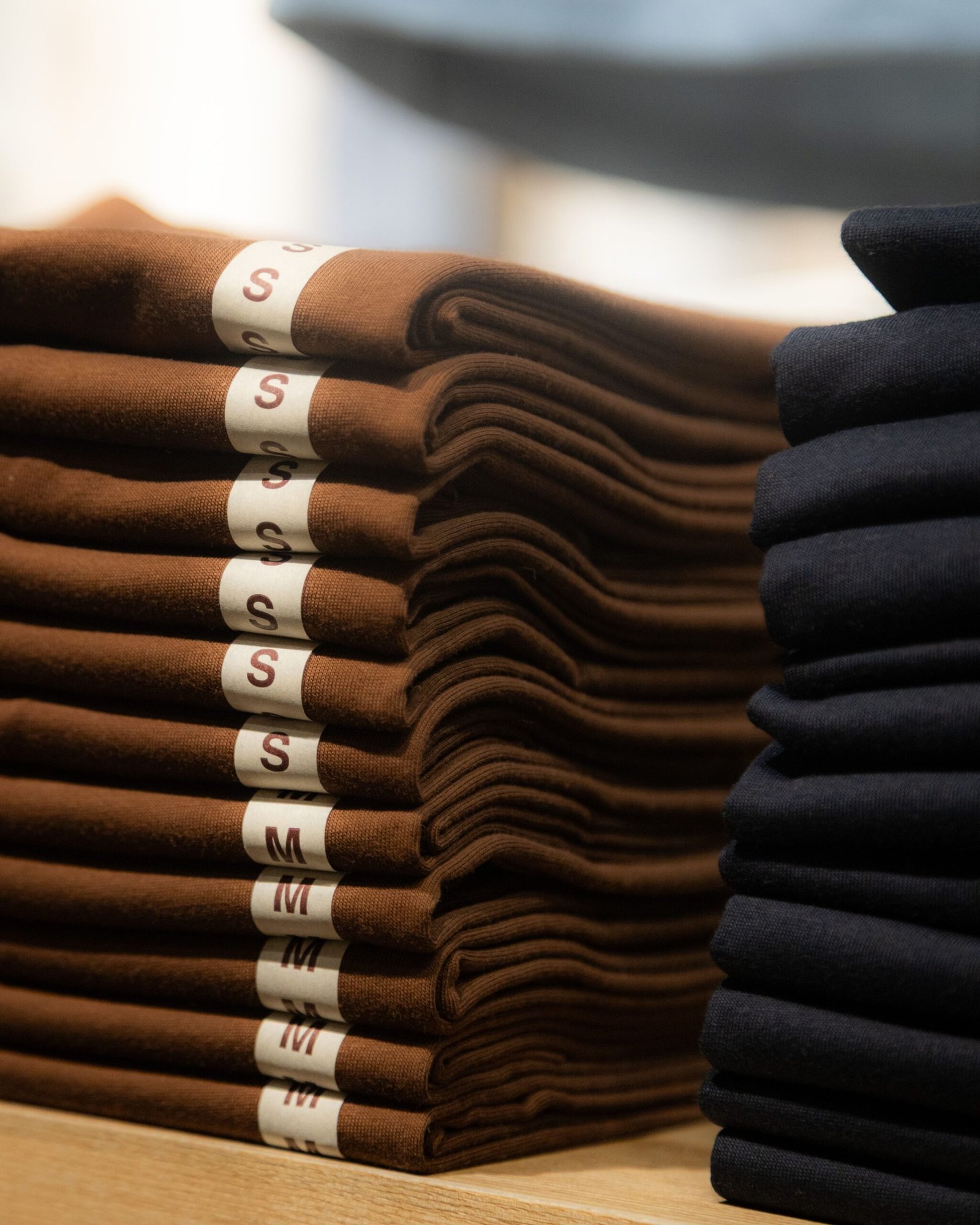 Home Neatly folded brown and black shirts in a retail store in Hà Nội, Vietnam.